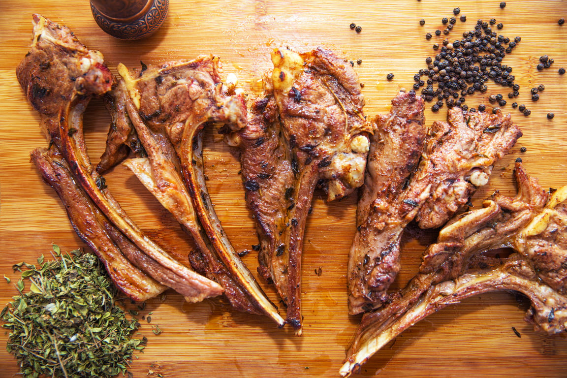 Azeri national antrikot kebab on a wooden board . Dry Satureja . Dried savory spice Satureja hortensis . Copper pepper dish . Antrikot kebabs .