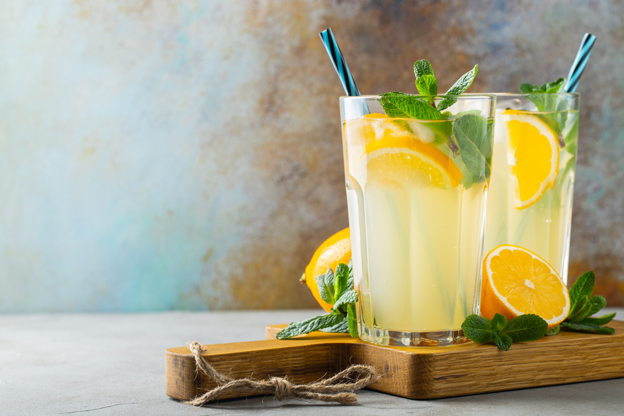 Two Glasses of Lemonade with Orange Slices and Mint Leaves